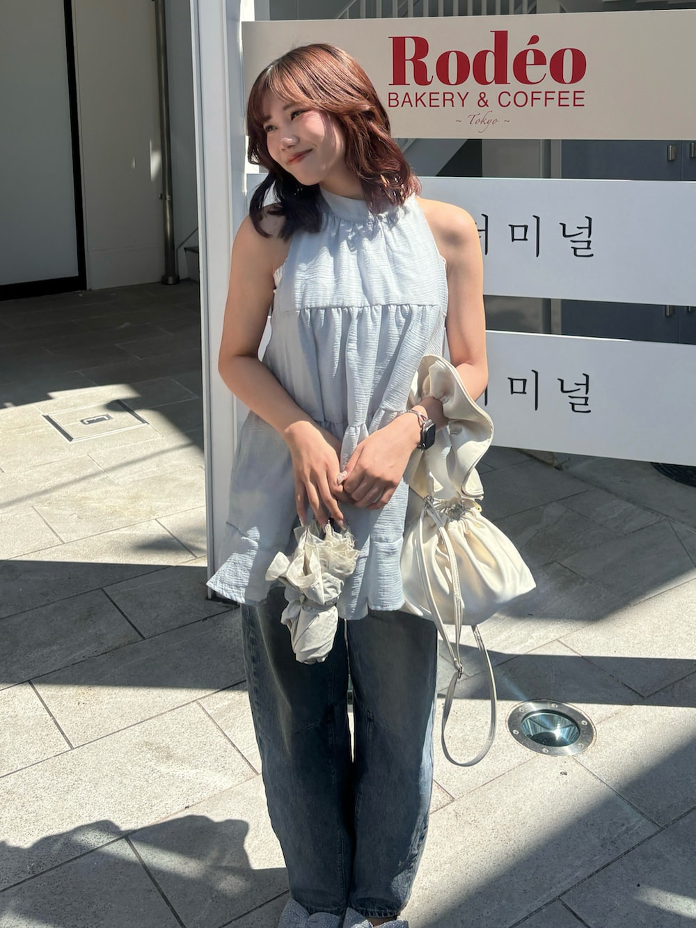シルバー系のパンプス、ブルー系のシャツ/ブラウス、ブルー系のデニムパンツを着用したレディースの夏コーディネートの3枚目の写真