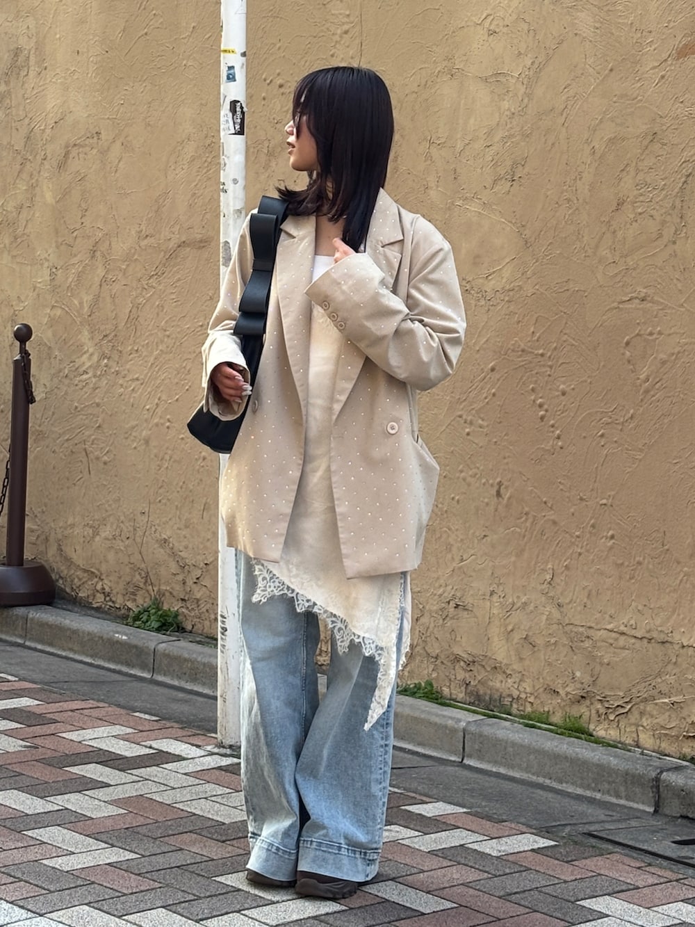 ブラウン系のローファー、ベージュ系のテーラードジャケット、ホワイト系のワンピースを着用したレディースの春コーディネートの3枚目の写真