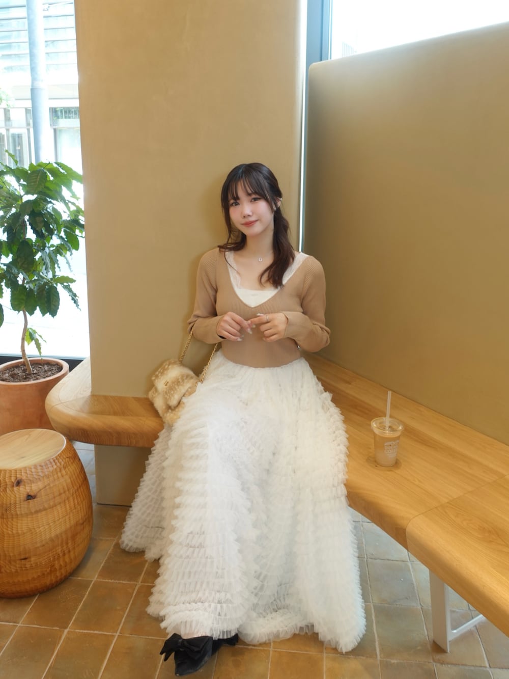 ベージュ系のハンドバッグ、イエロー系のワンピースを着用したレディースの秋コーディネートの3枚目の写真