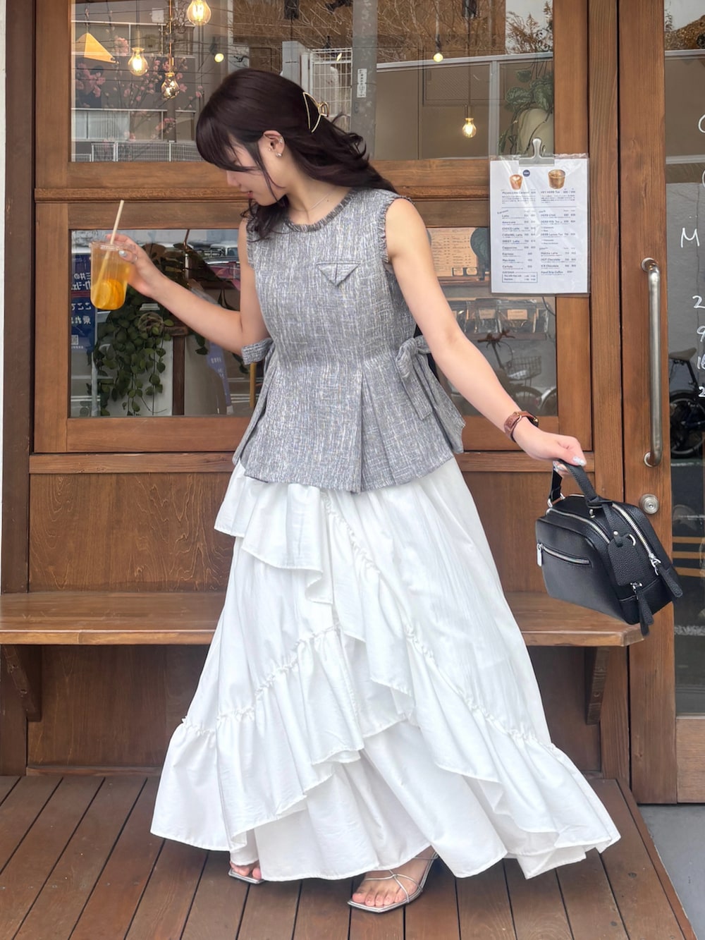 グレー系のシャツ/ブラウス、ホワイト系のスカート、ブラック系のボストンバッグを着用したレディースの春コーディネートの2枚目の写真