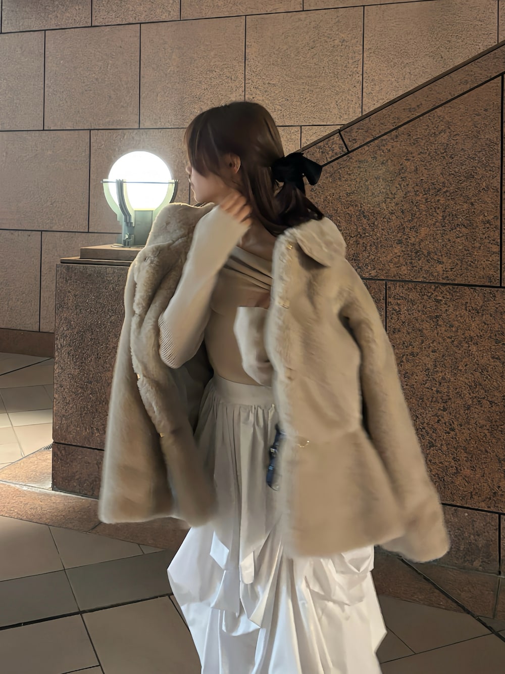 ブラック系のハンドバッグ、ピンク系のニット/セーター、ベージュ系のその他アウターを着用したレディースの冬コーディネートの3枚目の写真