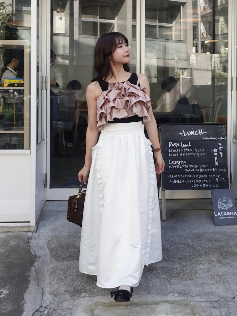 ブラック系のパンプス、ピンク系のキャミソール、ホワイト系のスカートを着用したレディースの春コーディネートの2枚目の写真