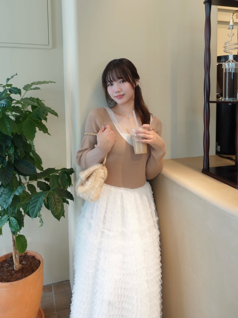 ベージュ系のハンドバッグ、イエロー系のワンピースを着用したレディースの秋コーディネートの2枚目の写真