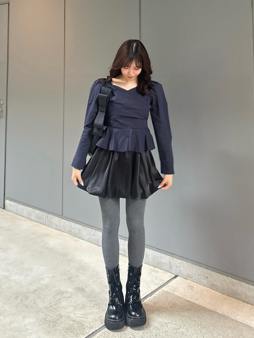 ブルー系のシャツ/ブラウス、ブラック系のショルダーバッグ、ブラック系のブーツを着用したレディースの春コーディネートの2枚目の写真