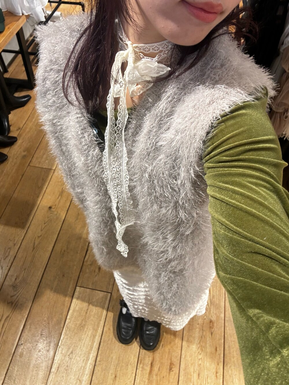 ブラック系のローファー、グレー系のベスト、ホワイト系のスカートを着用したレディースの冬コーディネートの4枚目の写真