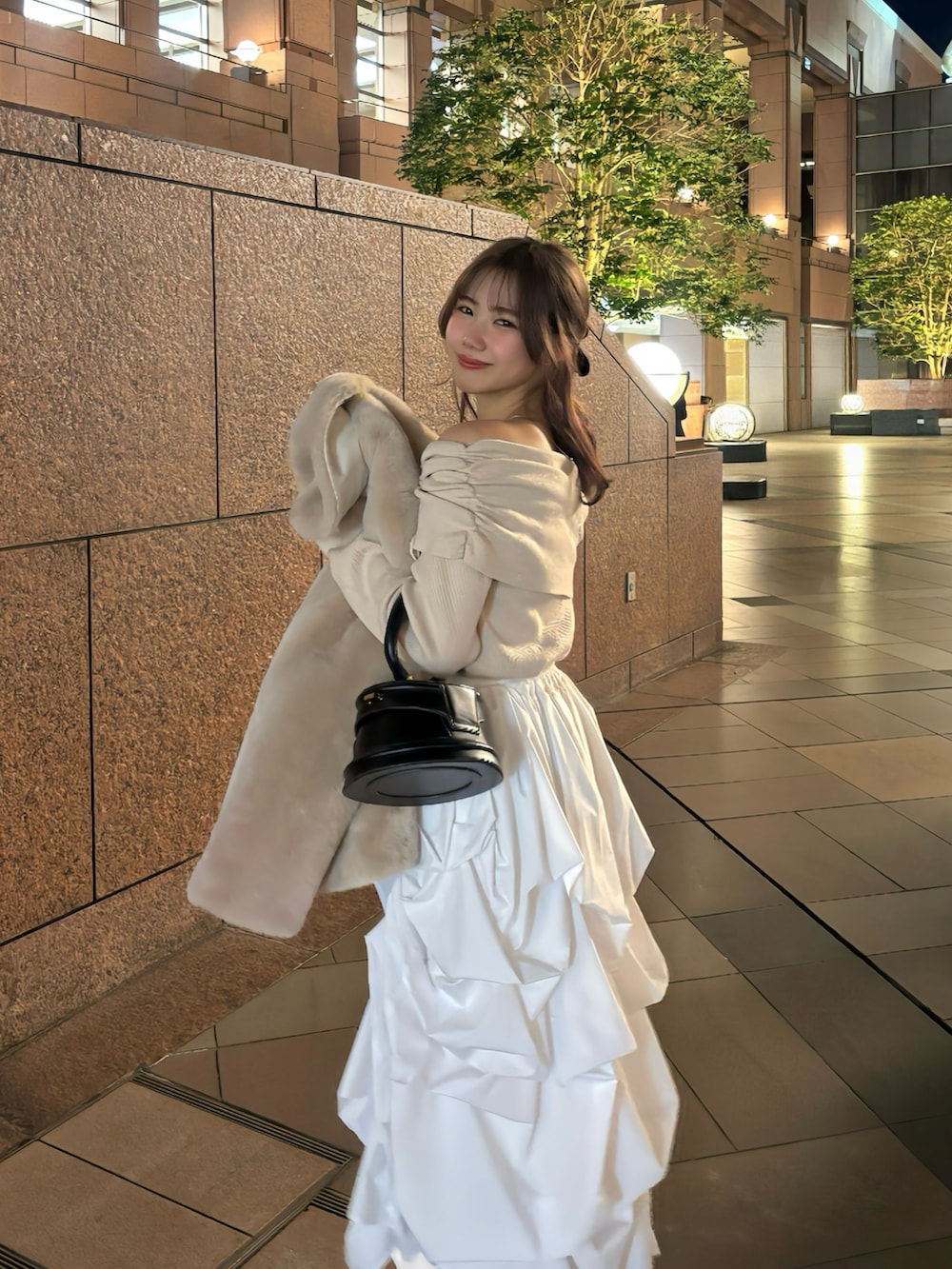 ブラック系のハンドバッグ、ピンク系のニット/セーター、ベージュ系のその他アウターを着用したレディースの冬コーディネートの2枚目の写真