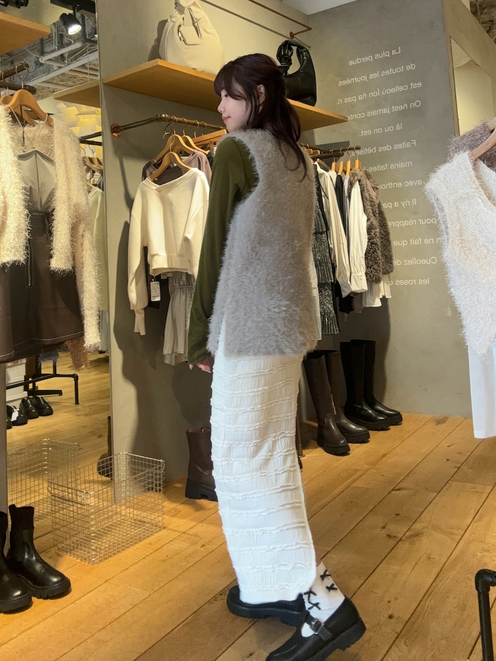 ブラック系のローファー、グレー系のベスト、ホワイト系のスカートを着用したレディースの冬コーディネートの3枚目の写真