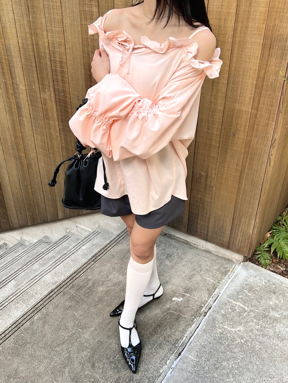 ピンク系のシャツ/ブラウス、グレー系のその他パンツ、ブラック系のパンプスを着用したレディースの春コーディネートの2枚目の写真