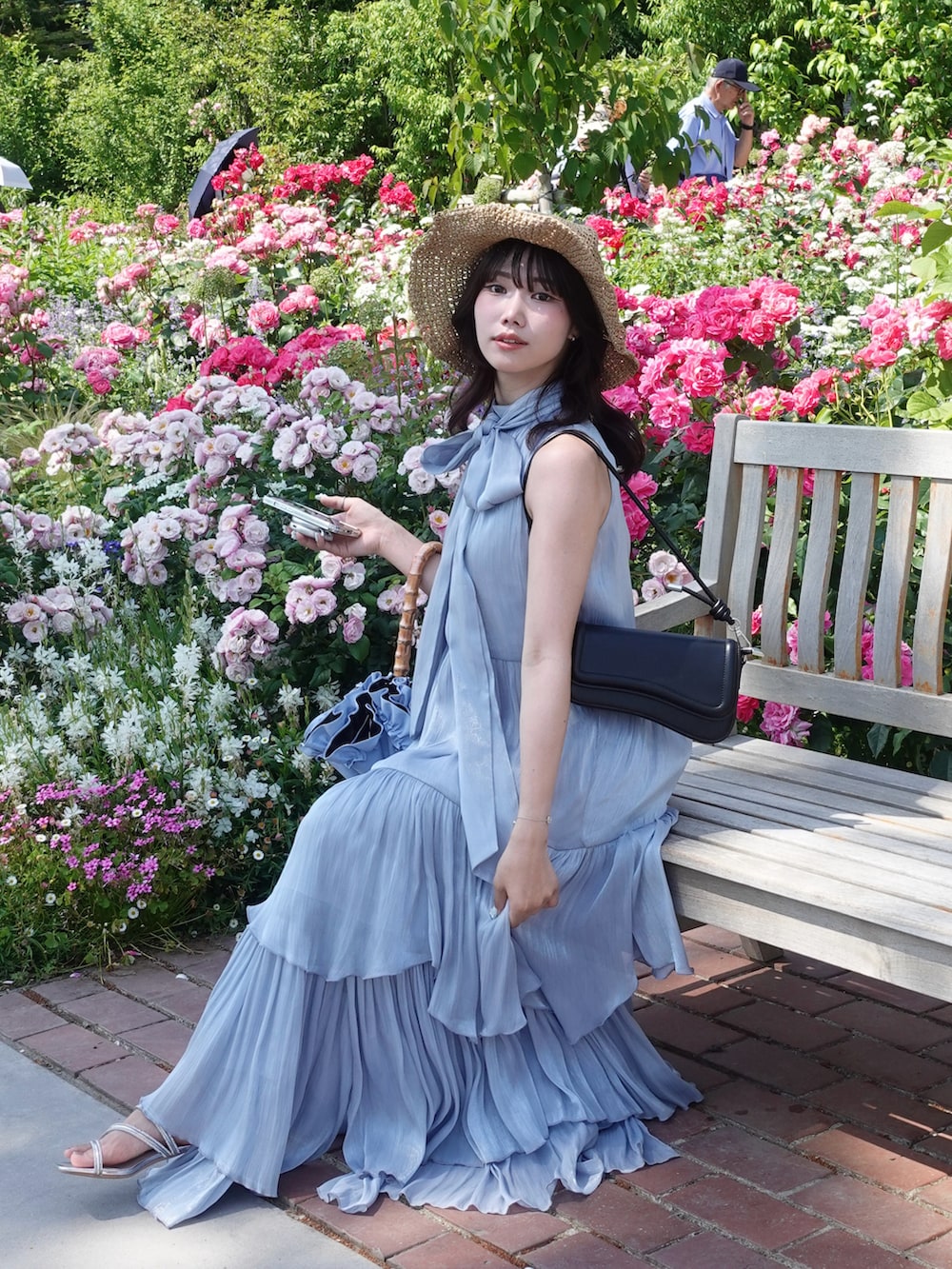 ブルー系のワンピース、ブラック系のショルダーバッグ、シルバー系のサンダルを着用したレディースの夏コーディネートの3枚目の写真