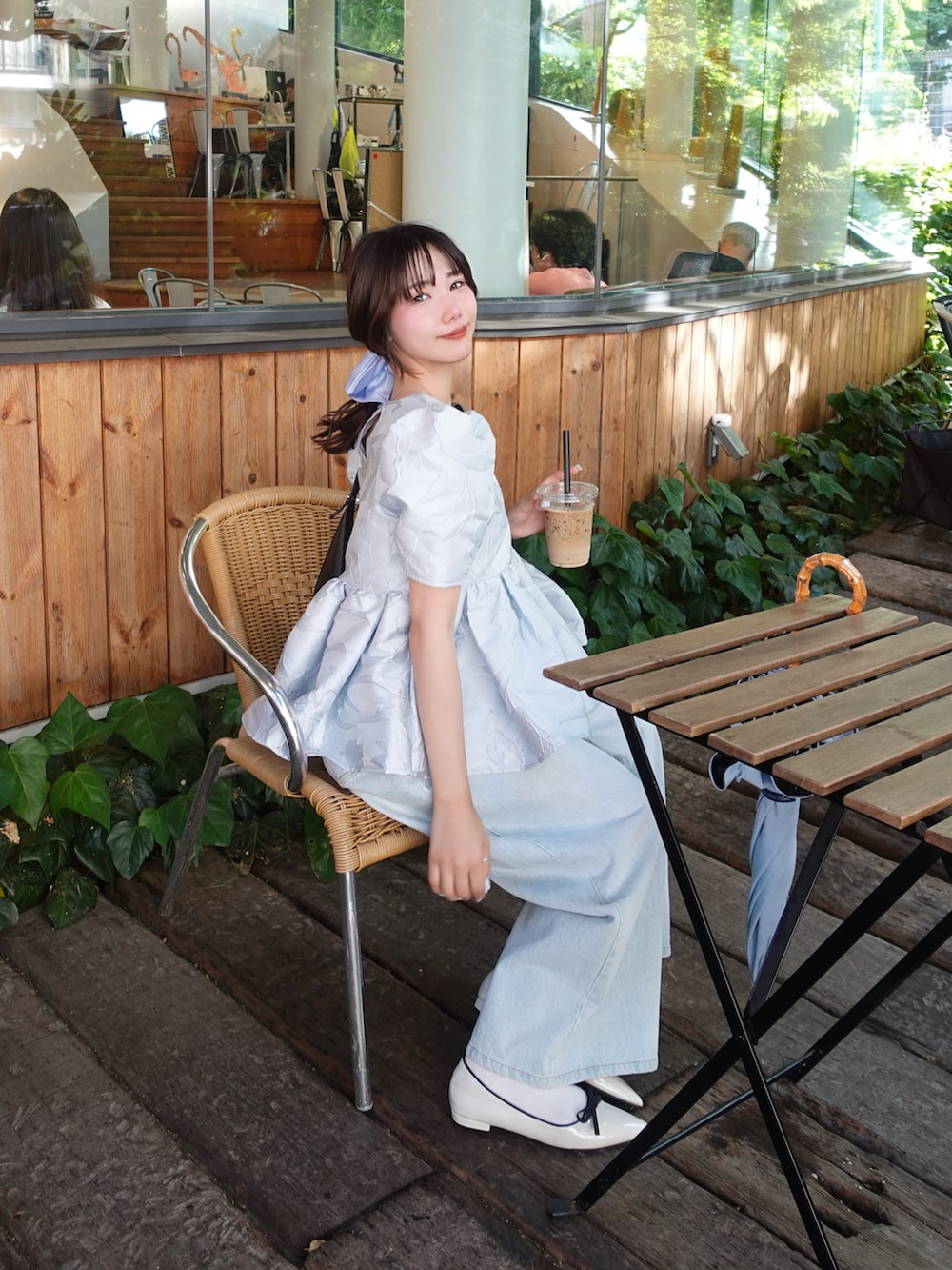ブラック系のシャツ/ブラウス、ブラック系のショルダーバッグ、ブルー系のデニムパンツを着用したレディースの春コーディネートの3枚目の写真