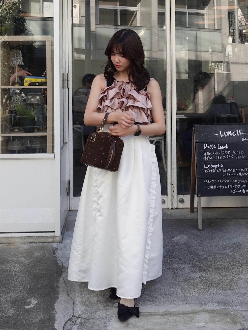 ブラック系のパンプス、ピンク系のキャミソール、ホワイト系のスカートを着用したレディースの春コーディネートの3枚目の写真