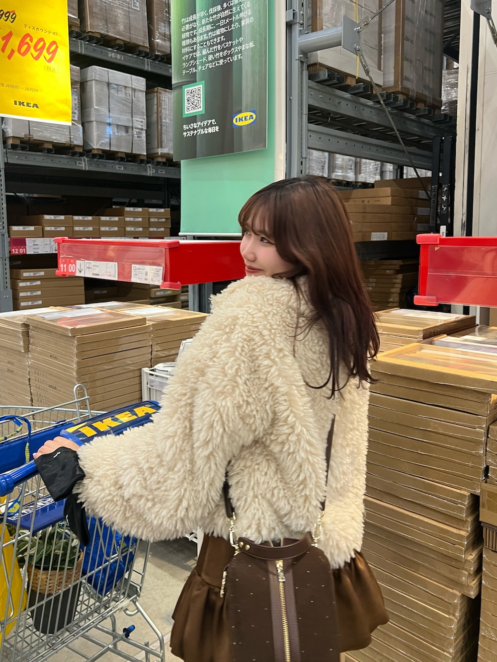 ブラウン系のブーツ、ブラウン系のスカート、ホワイト系のその他アウターを着用したレディースの冬コーディネートの3枚目の写真