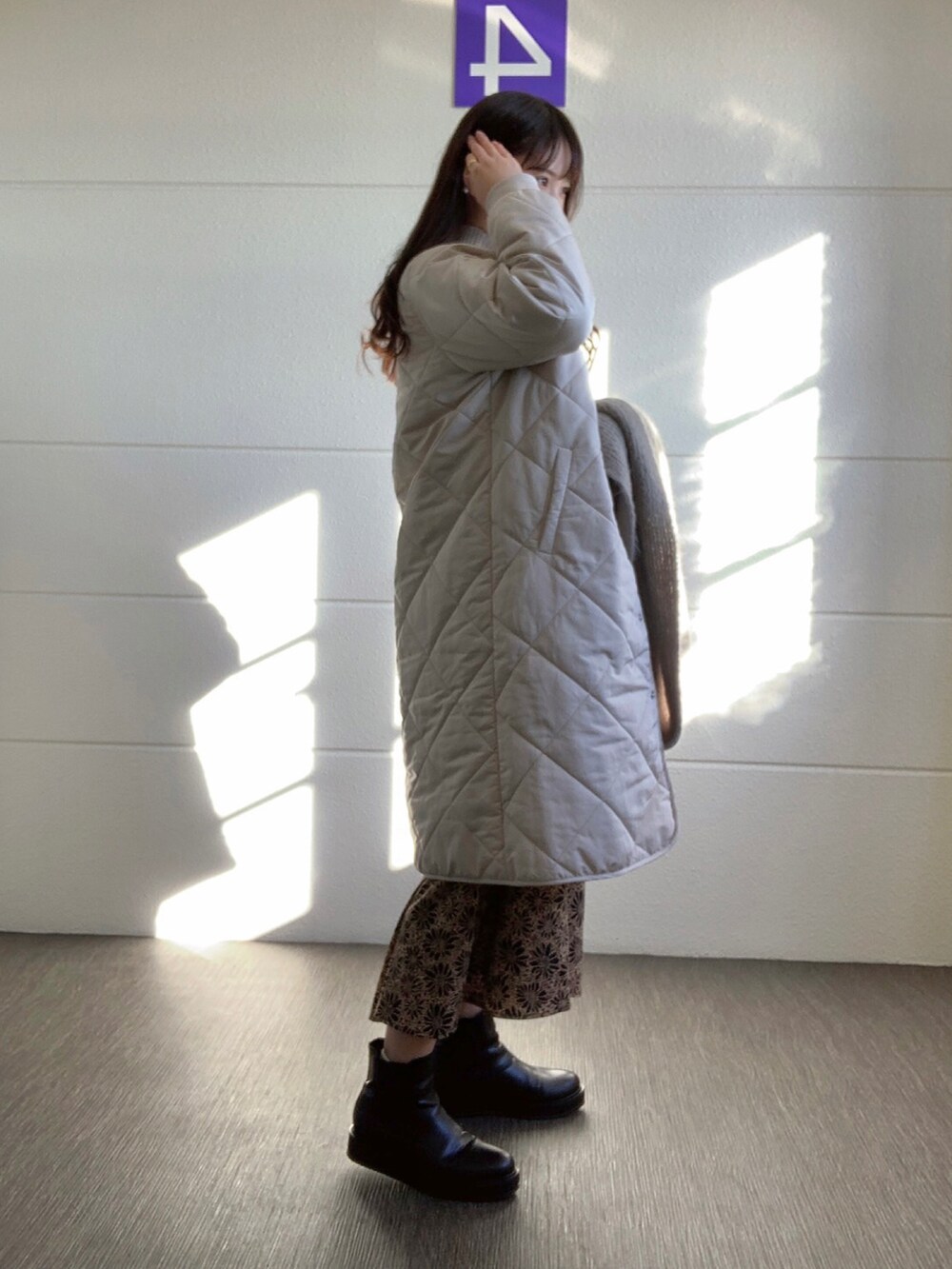 ブラック系のワンピース、ベージュ系のその他アウター、グレー系のニット/セーターを着用したレディースの冬コーディネートの2枚目の写真