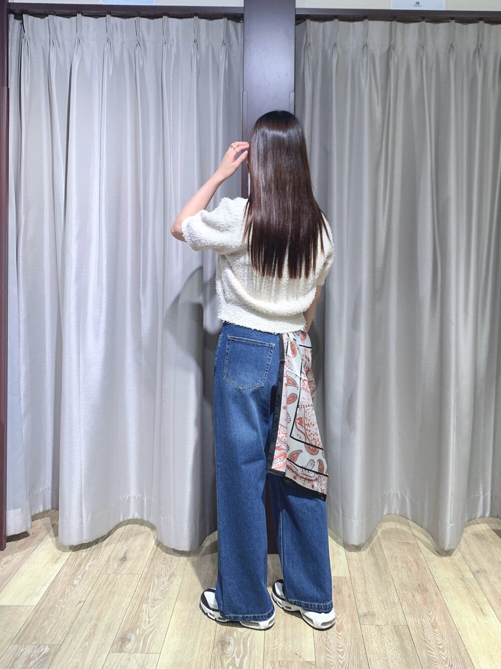 ホワイト系のニット/セーター、ブルー系のデニムパンツを着用したレディースの秋コーディネートの2枚目の写真