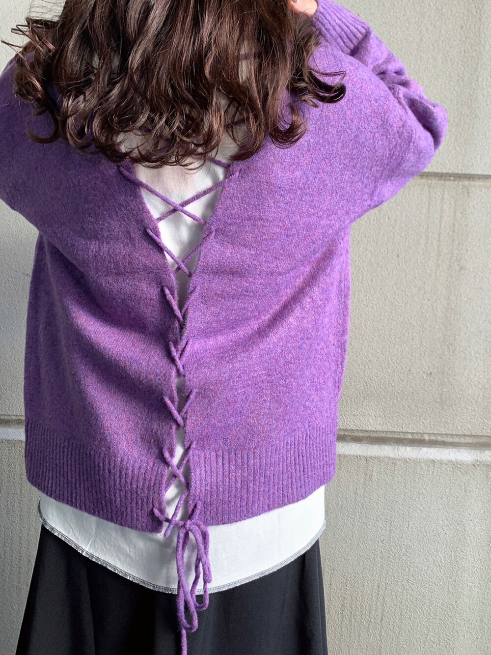 パープル系のニット/セーター、ホワイト系のTシャツ/カットソー、ブラック系のスカートを着用したレディースの冬コーディネートの4枚目の写真