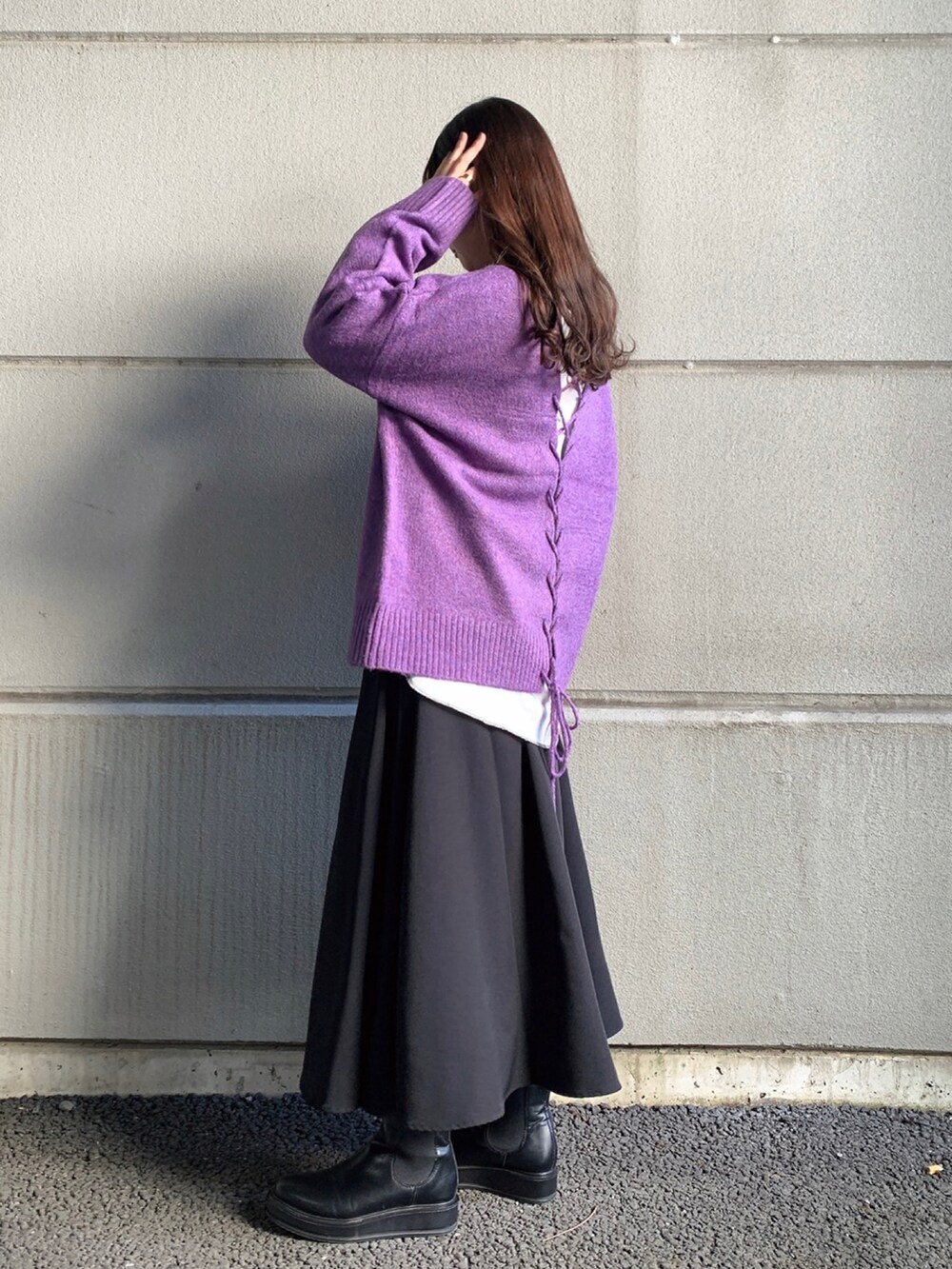 パープル系のニット/セーター、ホワイト系のTシャツ/カットソー、ブラック系のスカートを着用したレディースの冬コーディネートの2枚目の写真