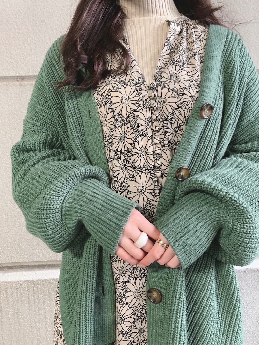 ベージュ系のワンピース、グリーン系のカーディガン/ボレロ、ベージュ系のニット/セーターを着用したレディースの冬コーディネートの2枚目の写真