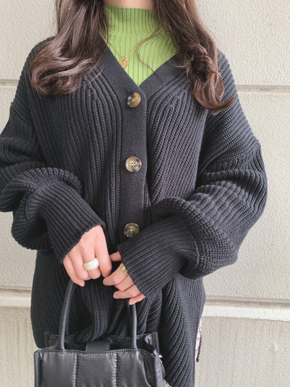 ブラック系のカーディガン/ボレロ、グリーン系のニット/セーター、ブラック系のショルダーバッグを着用したレディースの冬コーディネートの2枚目の写真