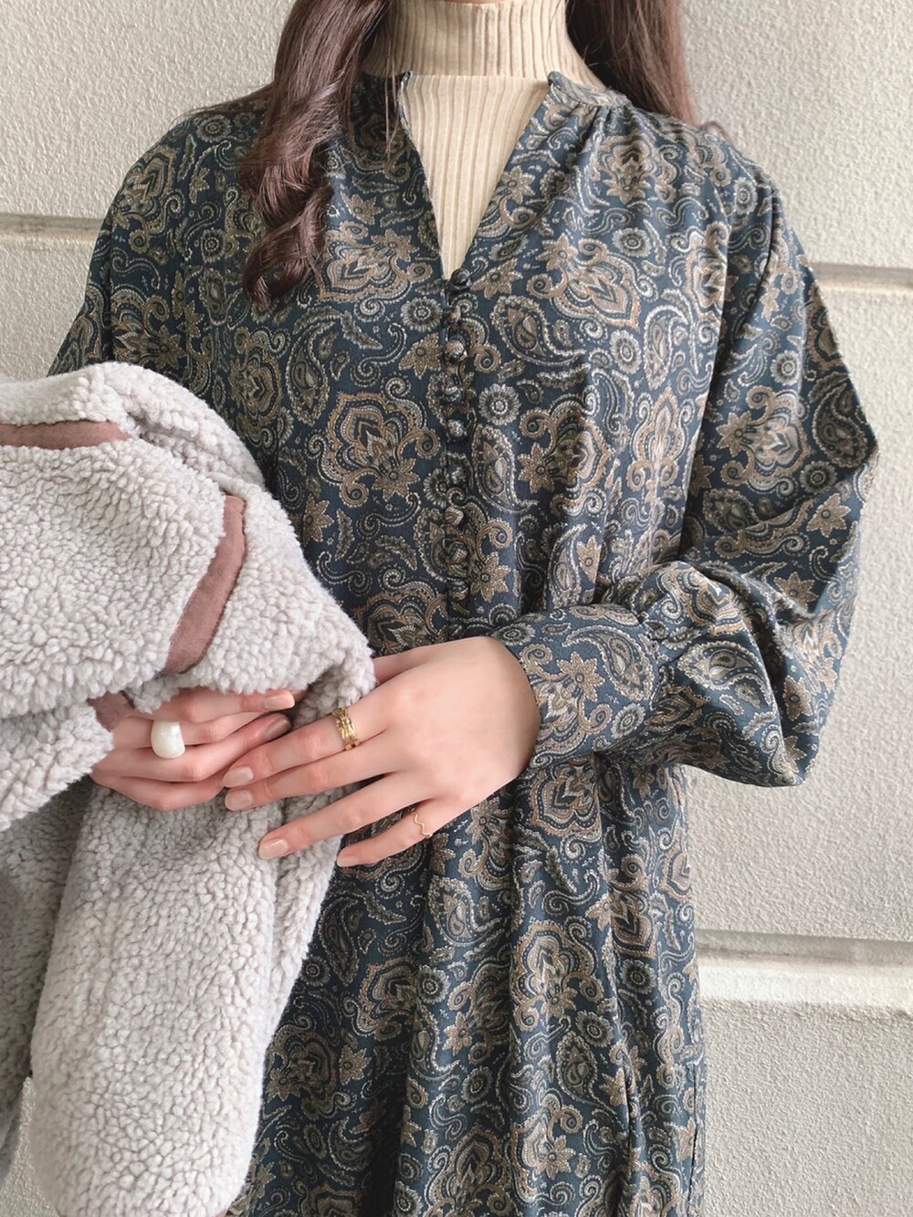 ブラック系のワンピース、ベージュ系のニット/セーター、グレー系のその他アウターを着用したレディースの冬コーディネートの3枚目の写真