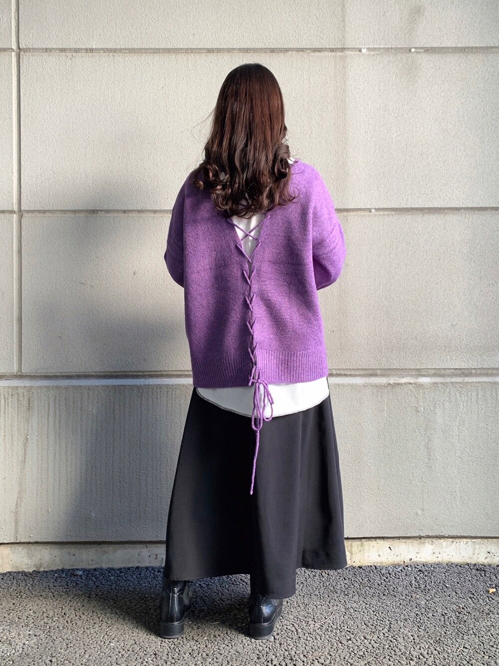 パープル系のニット/セーター、ホワイト系のTシャツ/カットソー、ブラック系のスカートを着用したレディースの冬コーディネートの3枚目の写真