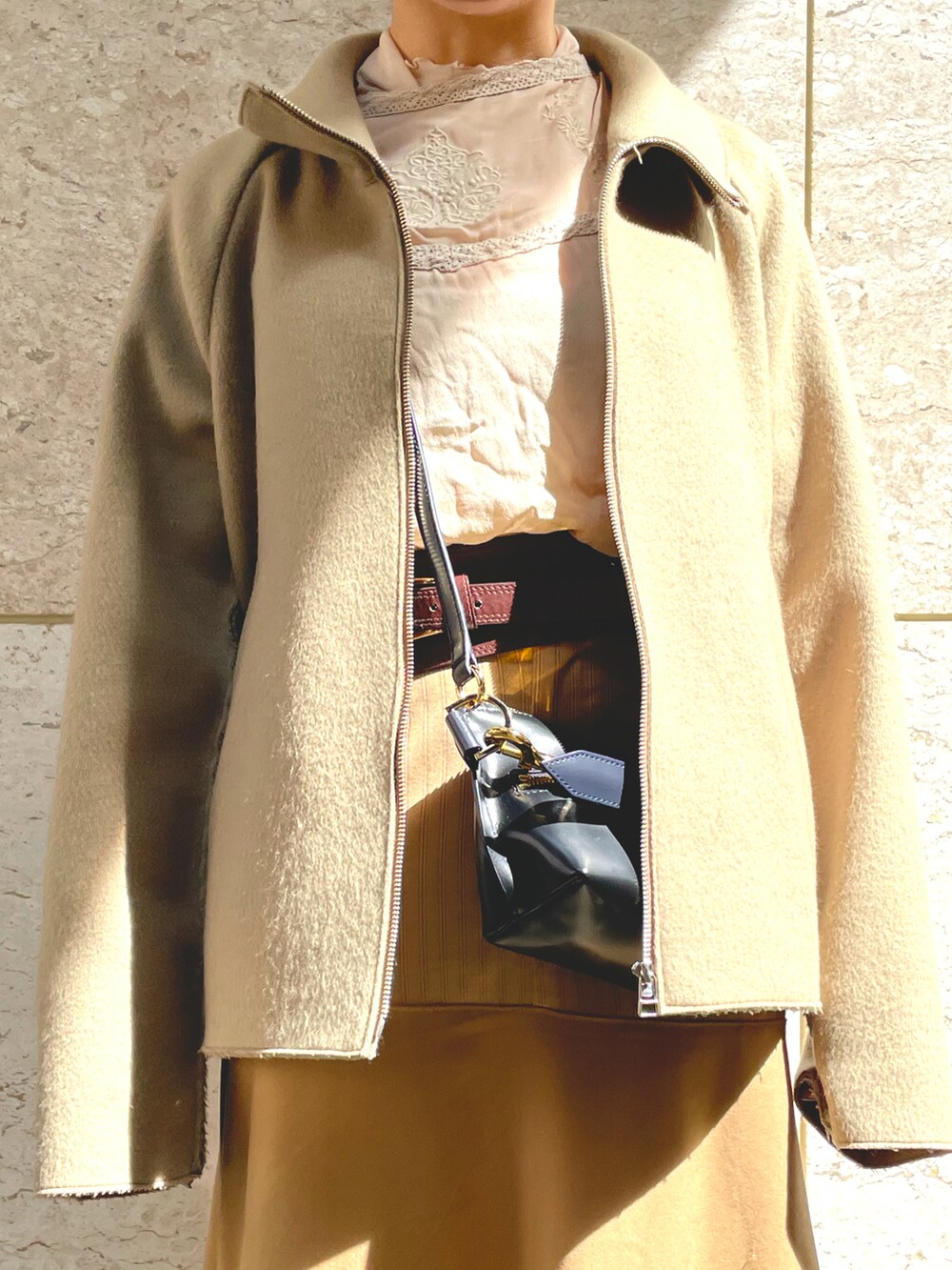 グリーン系のブルゾン、ベージュ系のスカート、ホワイト系のシューズを着用したレディースの春コーディネートの2枚目の写真