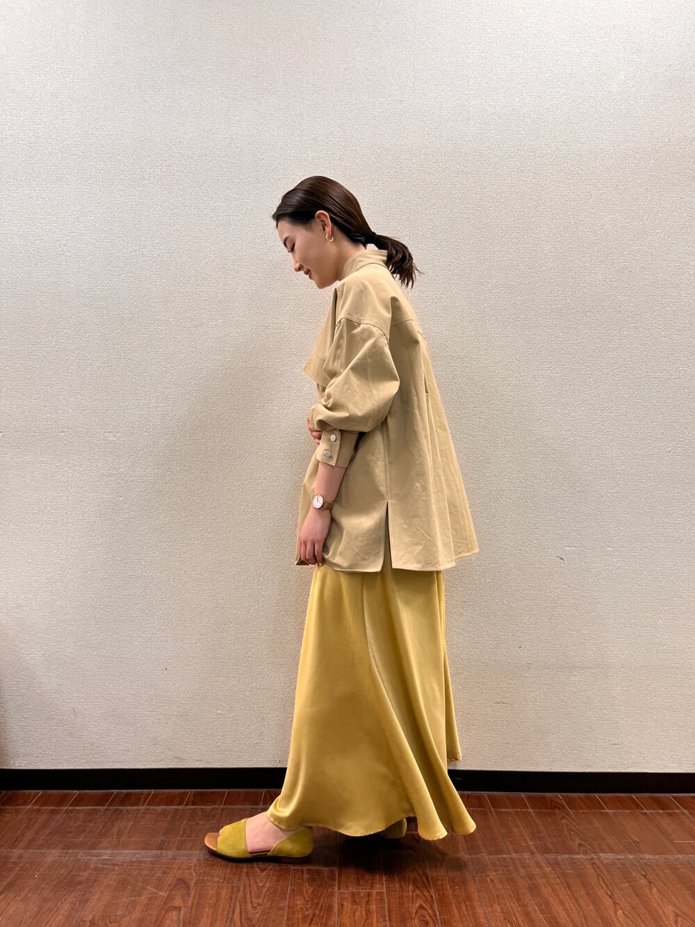 ベージュ系のカバーオール、イエロー系のスカートを着用したレディースの春コーディネートの2枚目の写真