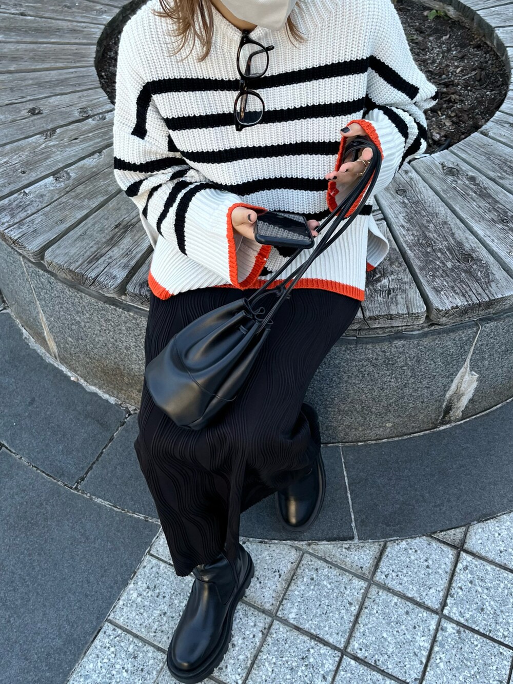 ホワイト系のニット/セーター、ブラック系のスカートを着用したレディースの秋コーディネートの2枚目の写真