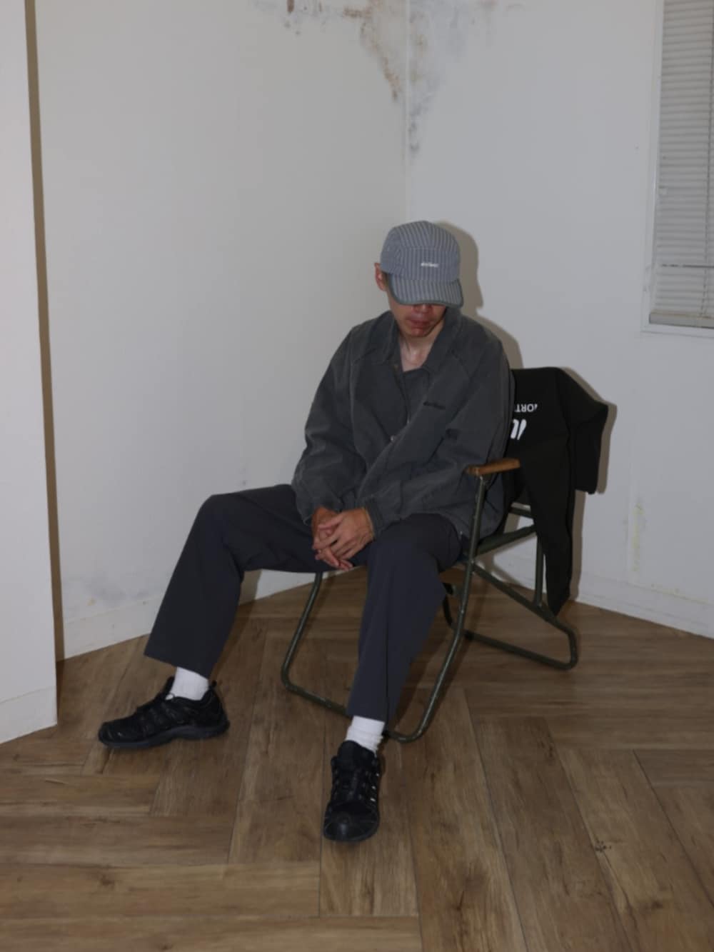 ブラック系のナイロンジャケット、グレー系のその他パンツ、グレー系のキャップを着用したメンズの夏コーディネートの2枚目の写真