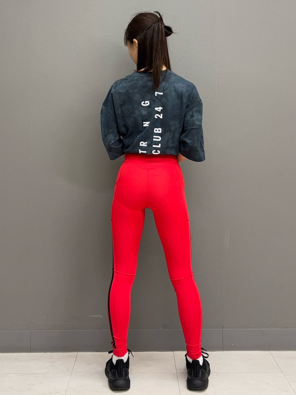 ブルー系のTシャツ/カットソー、ブラック系のシューズ、レッド系のレギンス/スパッツを着用したレディースの春コーディネートの2枚目の写真