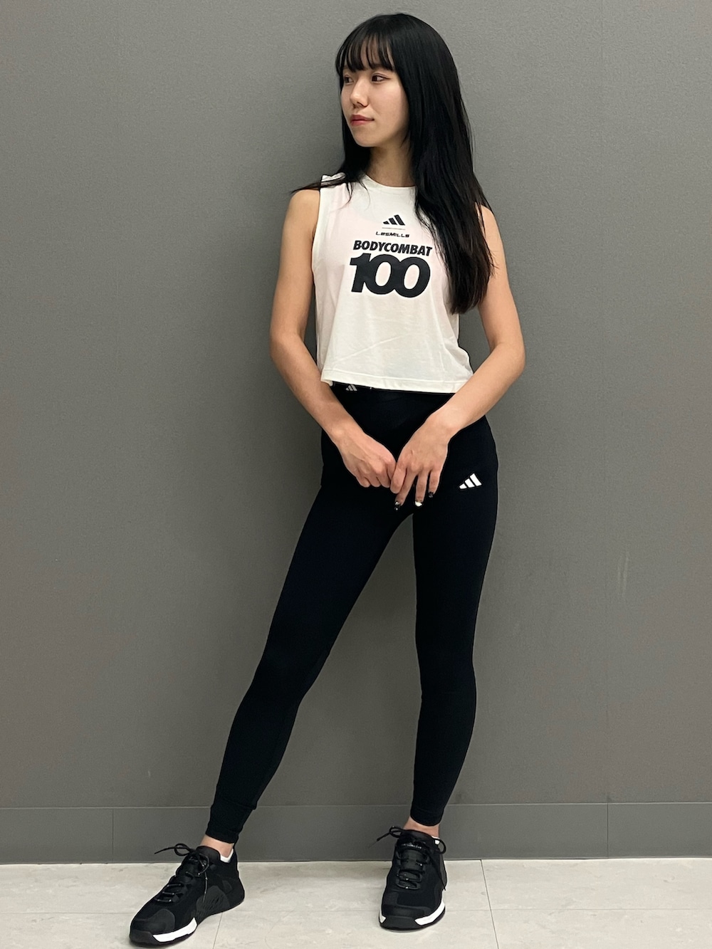 ホワイト系のトップス、ブラック系のシューズ、ブラック系のレギンス/スパッツを着用したレディースの秋コーディネートの2枚目の写真