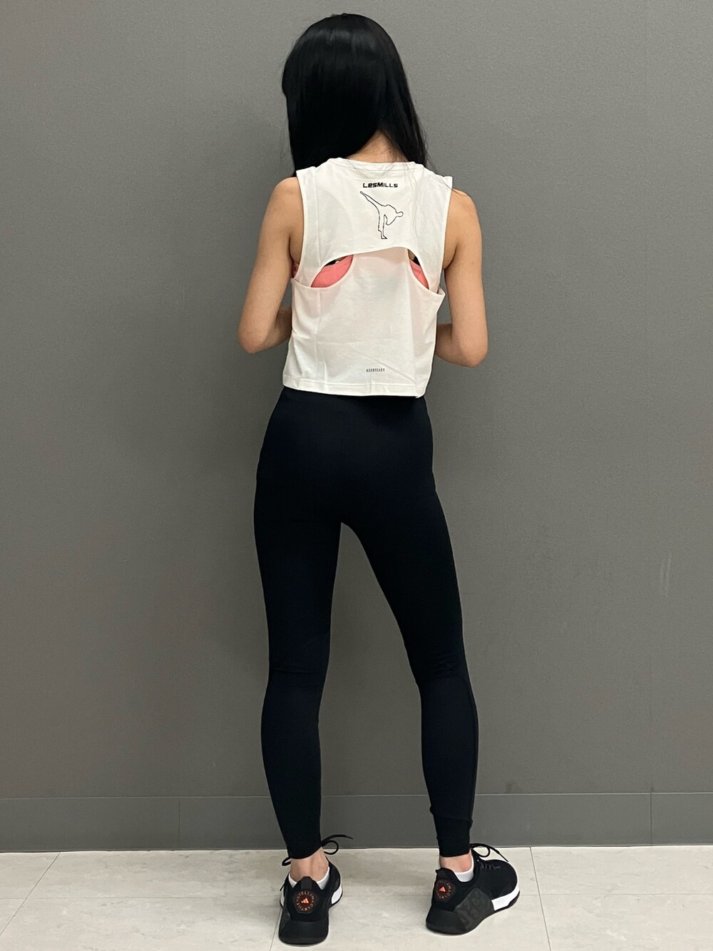 ホワイト系のトップス、ブラック系のシューズ、ブラック系のレギンス/スパッツを着用したレディースの秋コーディネートの3枚目の写真