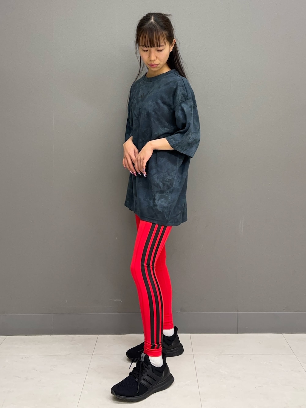 ブルー系のTシャツ/カットソー、ブラック系のシューズ、レッド系のレギンス/スパッツを着用したレディースの春コーディネートの3枚目の写真