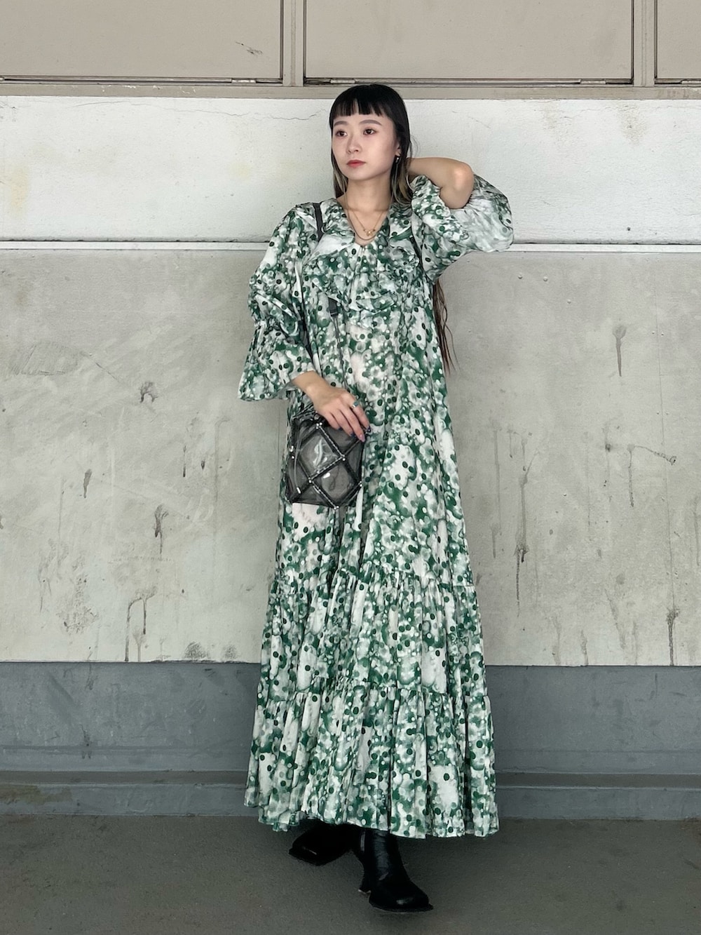 グレー系のショルダーバッグ、ブラック系のブーツ、グリーン系のドレスを着用したレディースの秋コーディネートの2枚目の写真