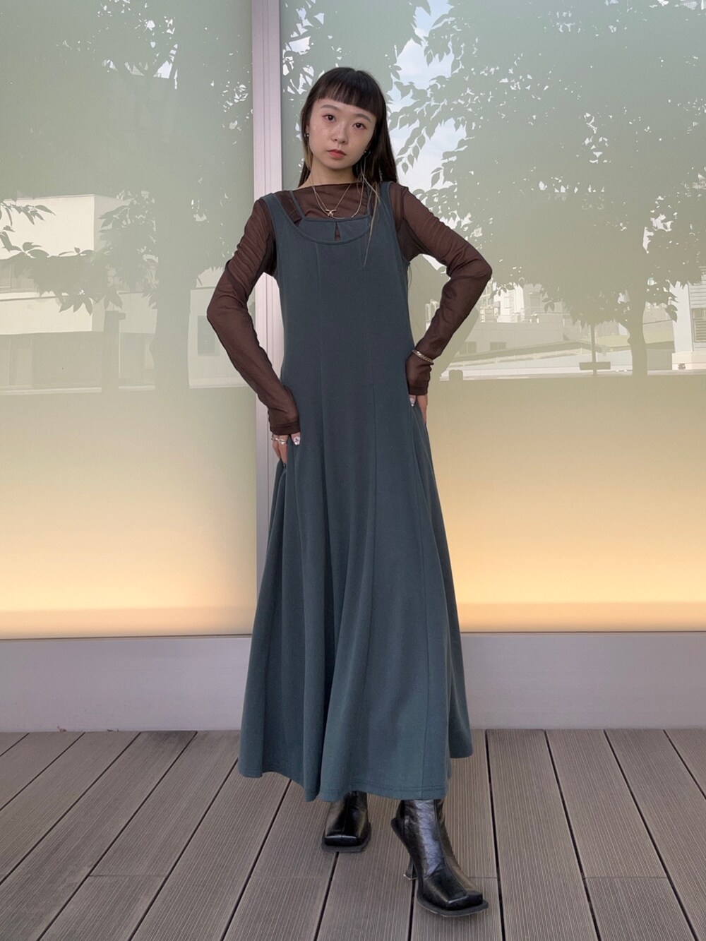 グリーン系のドレス、ブラウン系のTシャツ/カットソー、ブラック系のブーツを着用したレディースの秋コーディネートの4枚目の写真