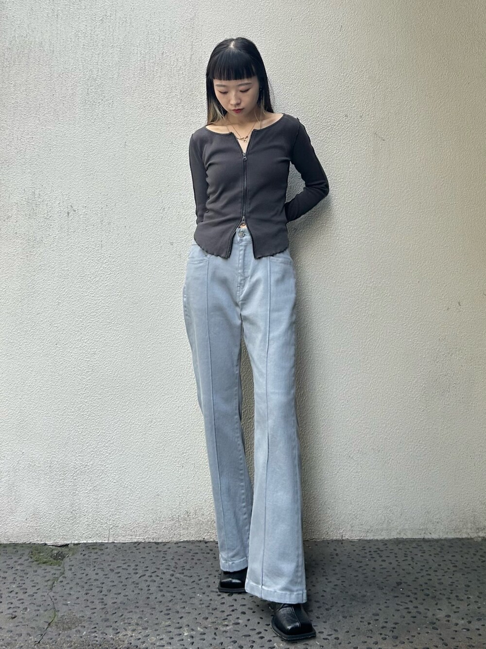グレー系のTシャツ/カットソー、ブルー系のデニムパンツ、ブラック系のブーツを着用したレディースの秋コーディネートの2枚目の写真