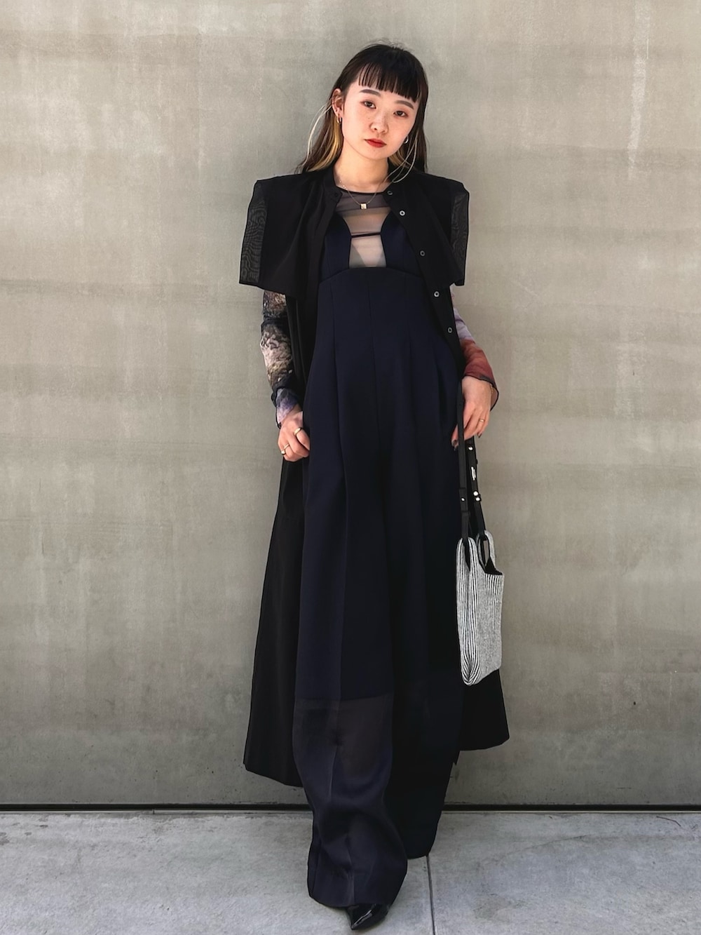 ブラック系のワンピース、シルバー系のショルダーバッグを着用したレディースの春コーディネートの4枚目の写真