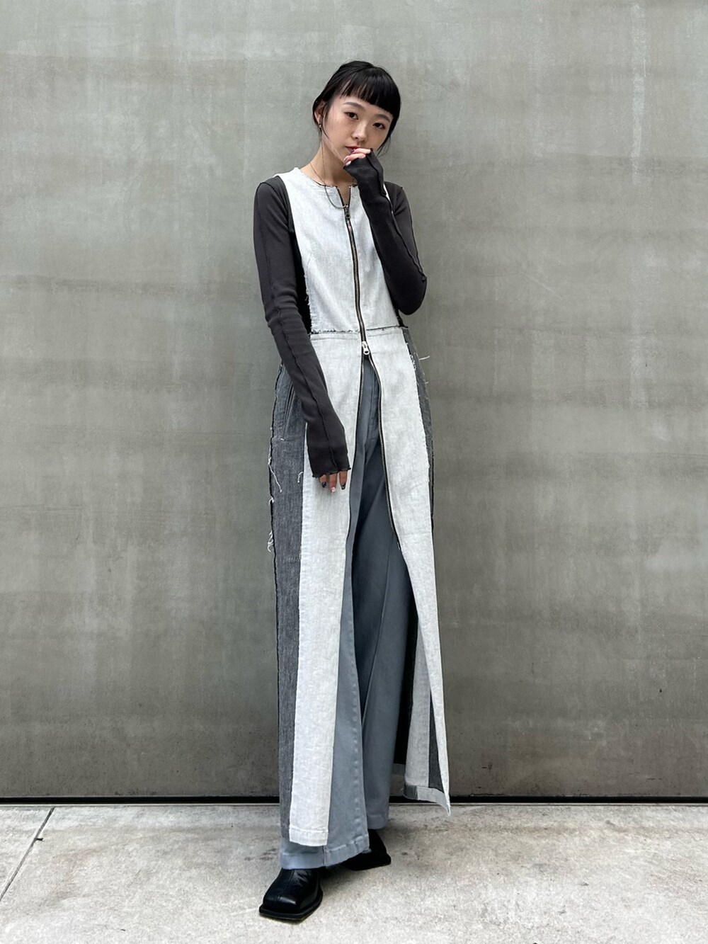 グレー系のTシャツ/カットソー、ブラック系のブーツ、ブルー系のデニムパンツを着用したレディースの秋コーディネートの3枚目の写真