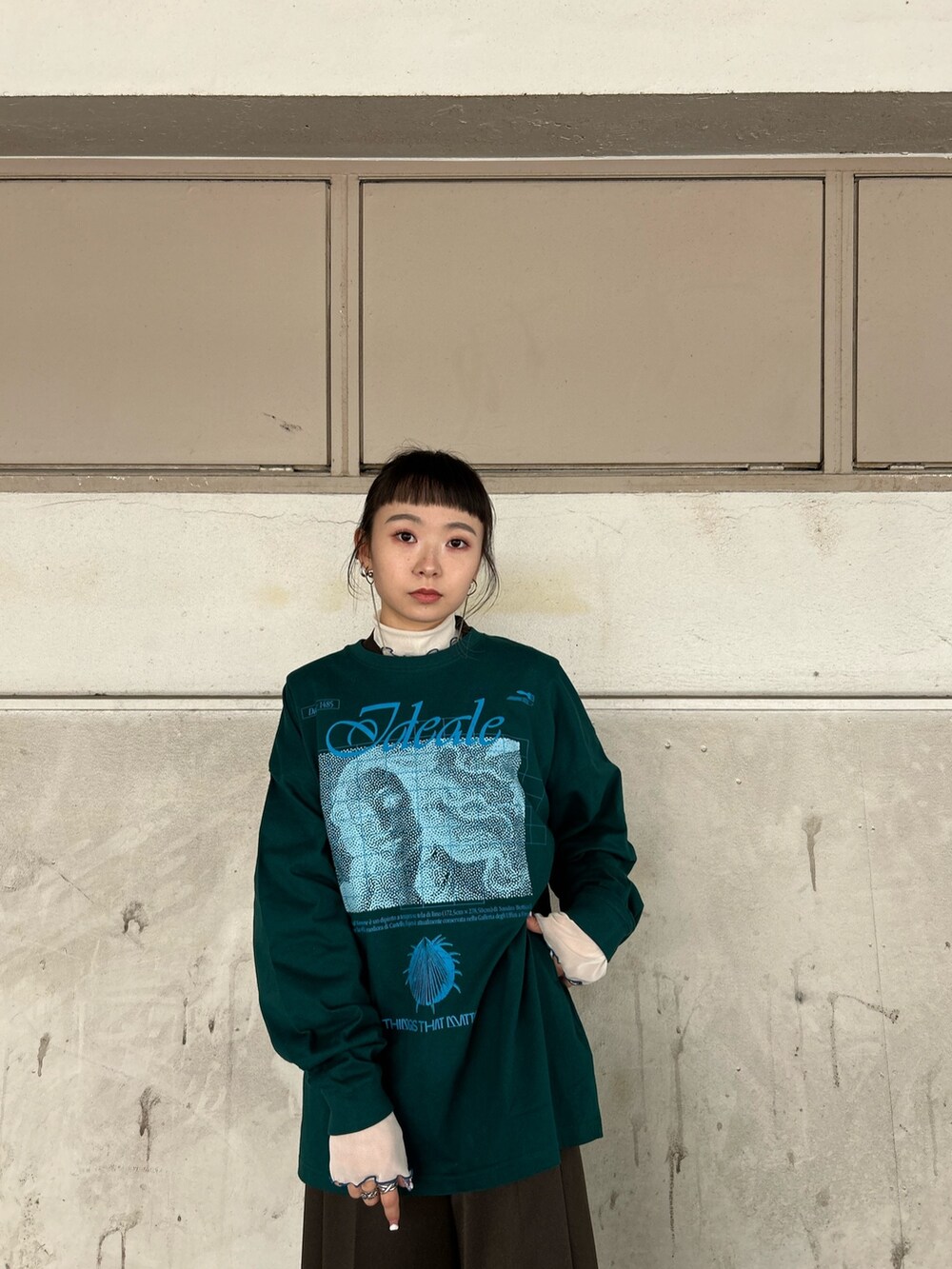 グリーン系のTシャツ/カットソー、ベージュ系のTシャツ/カットソー、ブラック系のブーツを着用したレディースの秋コーディネートの5枚目の写真