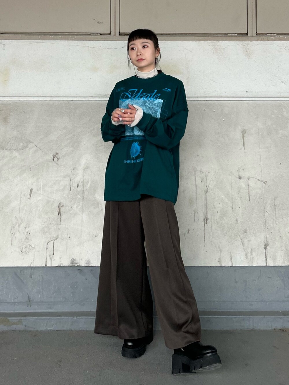 グリーン系のTシャツ/カットソー、ベージュ系のTシャツ/カットソー、ブラック系のブーツを着用したレディースの秋コーディネートの2枚目の写真