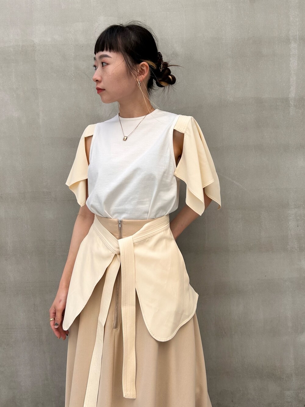 ベージュ系のスカート、ホワイト系のTシャツ/カットソーを着用したレディースの春コーディネートの4枚目の写真