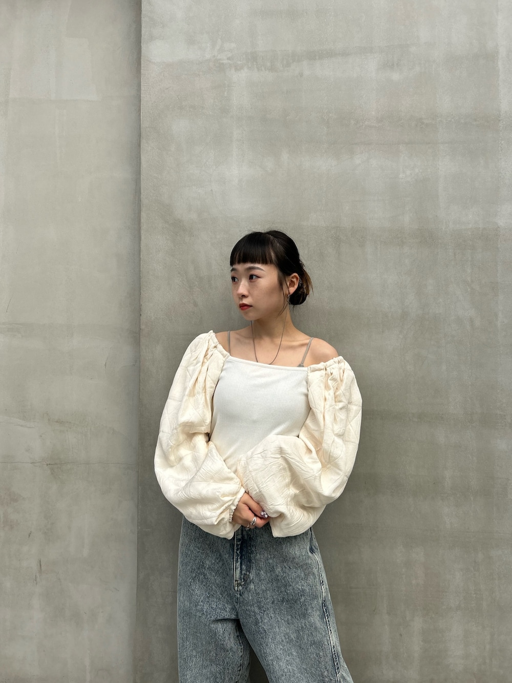 ブルー系のデニムパンツ、ホワイト系のTシャツ/カットソー、シルバー系のブーツを着用したレディースの秋コーディネートの4枚目の写真