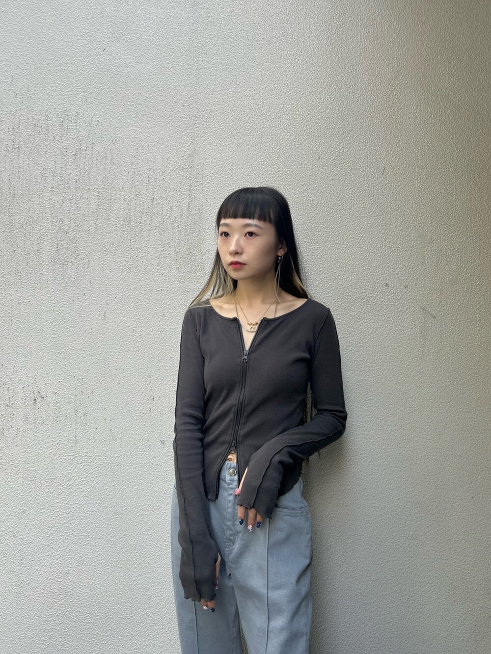 グレー系のTシャツ/カットソー、ブルー系のデニムパンツ、ブラック系のブーツを着用したレディースの秋コーディネートの5枚目の写真