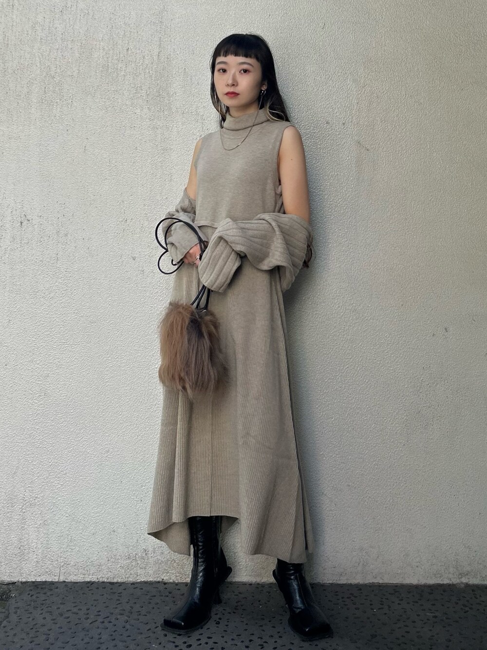 ベージュ系のワンピース、ブラウン系のハンドバッグ、ブラック系のブーツを着用したレディースの秋コーディネートの4枚目の写真