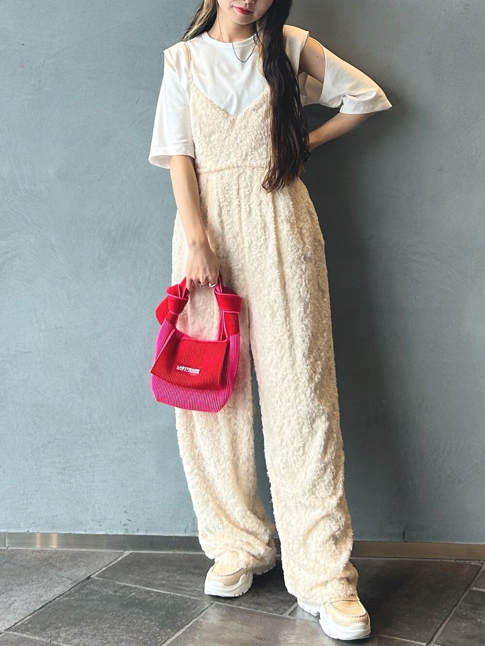 レッド系のハンドバッグ、ホワイト系のつなぎ/オールインワン、ホワイト系のTシャツ/カットソーを着用したレディースの春コーディネートの2枚目の写真