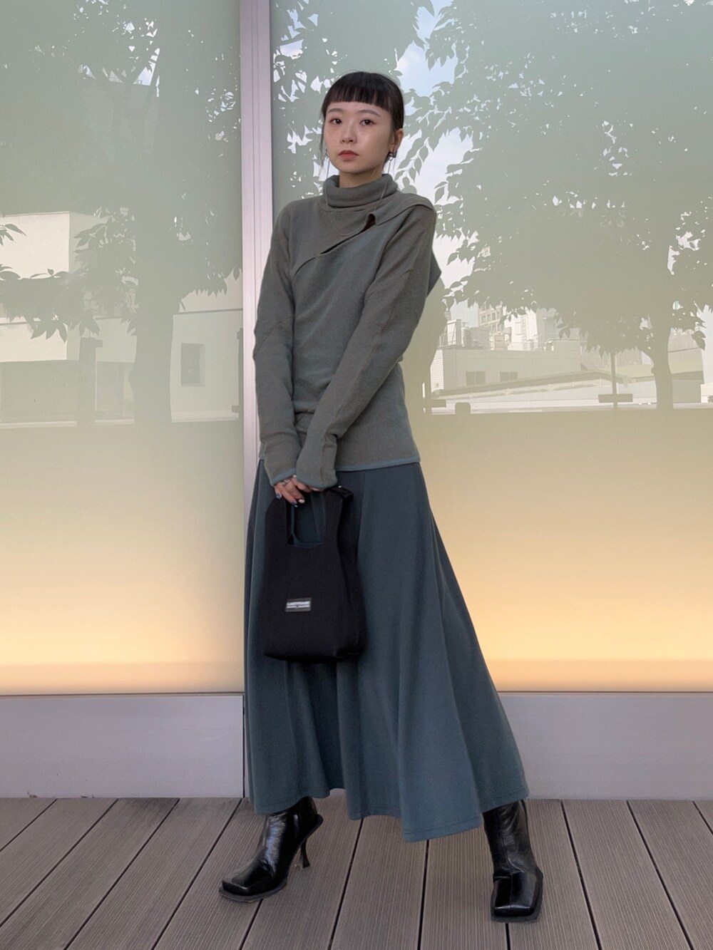 ブラック系のブーツ、グリーン系のドレスを着用したレディースの秋コーディネートの4枚目の写真