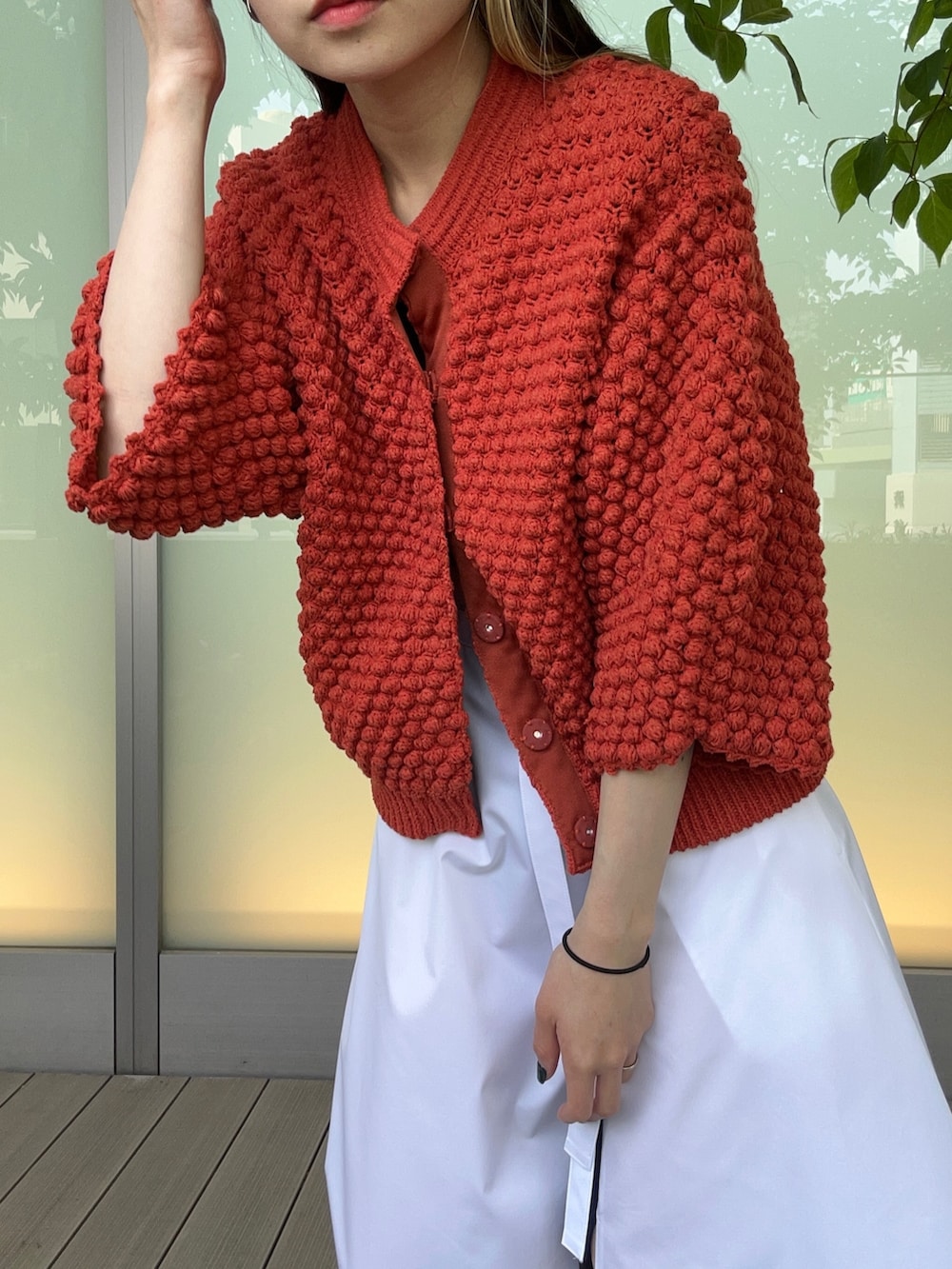 レッド系のカーディガン/ボレロ、ホワイト系のスカートを着用したレディースの春コーディネートの5枚目の写真