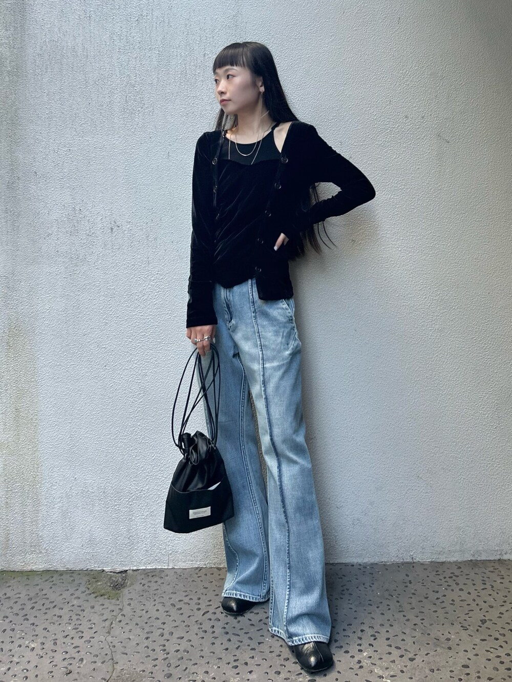 ブラック系のブーツ、ブラック系のショルダーバッグ、ブルー系のデニムパンツを着用したレディースの夏コーディネートの2枚目の写真