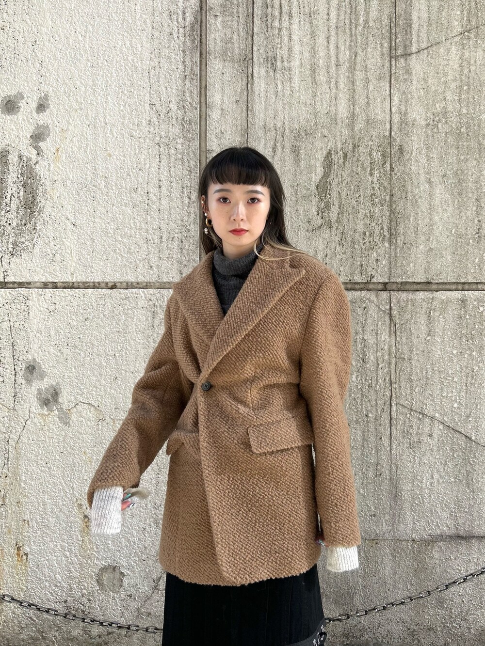 ブラック系のスカート、イエロー系のその他アウター、グリーン系のニット/セーターを着用したレディースの冬コーディネートの4枚目の写真