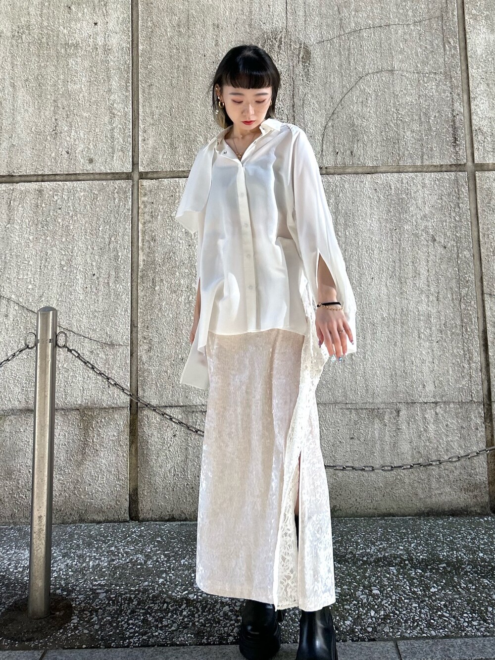 ホワイト系のスカート、ホワイト系のシャツ/ブラウス、ブラック系のブーツを着用したレディースの冬コーディネートの2枚目の写真