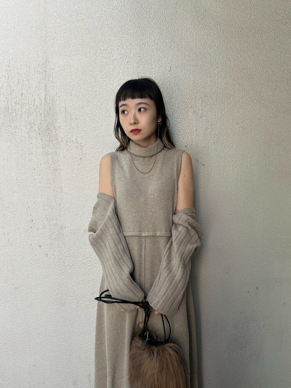 ベージュ系のワンピース、ブラウン系のハンドバッグ、ブラック系のブーツを着用したレディースの秋コーディネートの5枚目の写真